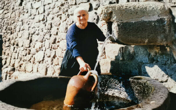Emilia Pisanu che raccoglie l'acqua alla fontana storica di Bonarcado (circa anni '95)